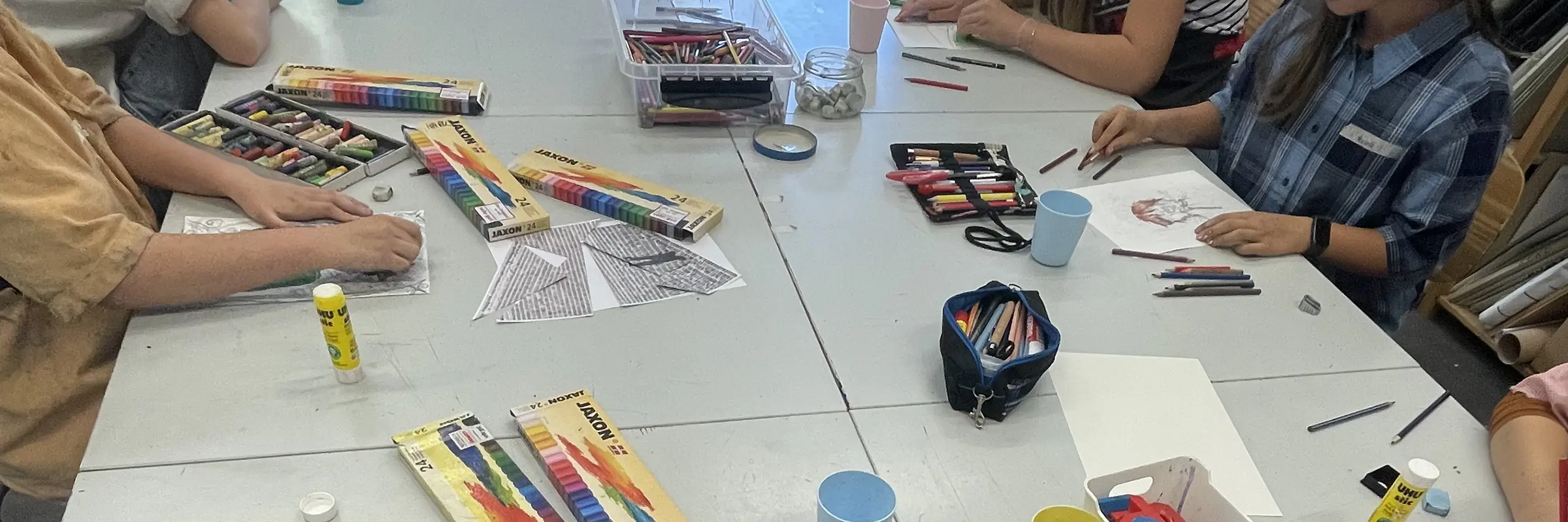 Kinder zeichnen gemeinsam an einem Tisch